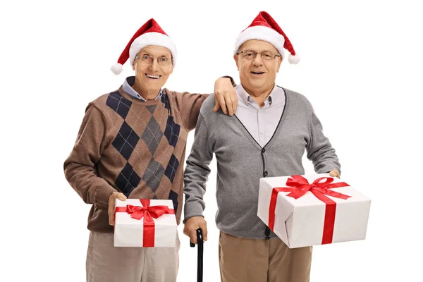 Men wearing santa hats and holding christmas presents — Stock Photo, Image