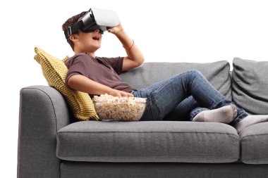 Çocuk Vr gözlük kullanma ve patlamış mısır yemek Divan
