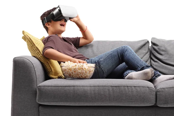 Niño en el sofá con gafas VR y comer palomitas de maíz — Foto de Stock