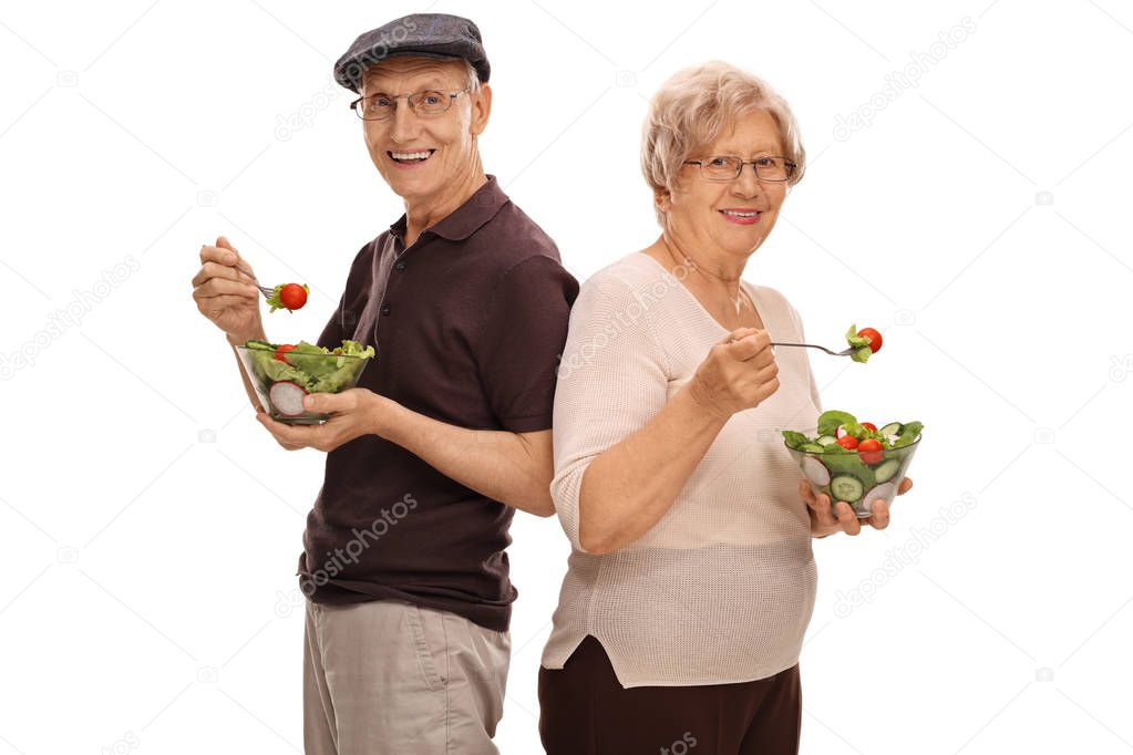 Mature man and woman eating salads