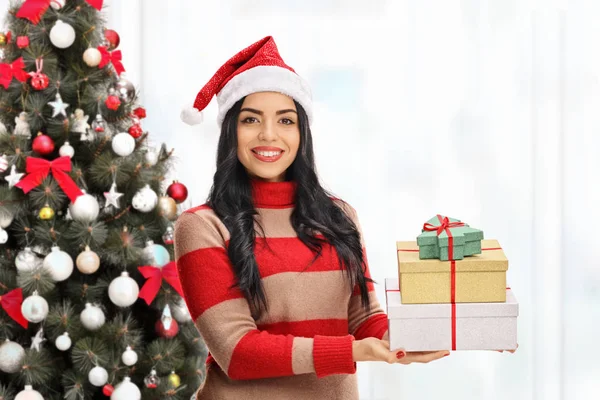 Mulher com presentes na frente de uma árvore de Natal — Fotografia de Stock