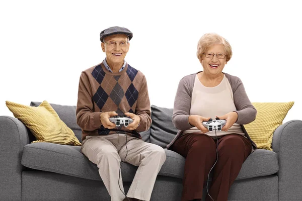 Idosos em um sofá jogando videogames — Fotografia de Stock