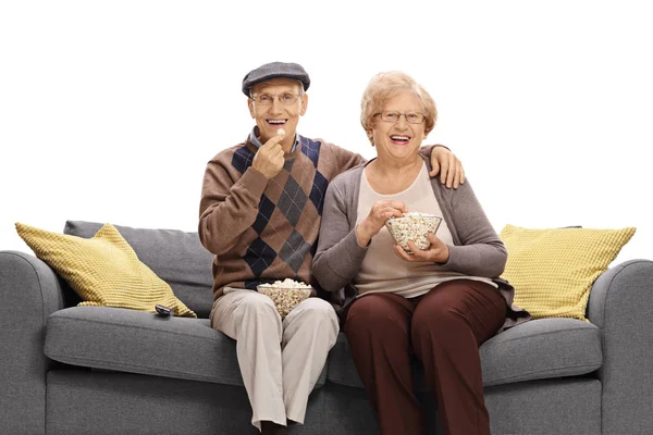 Äldre par på soffa äta popcorn — Stockfoto