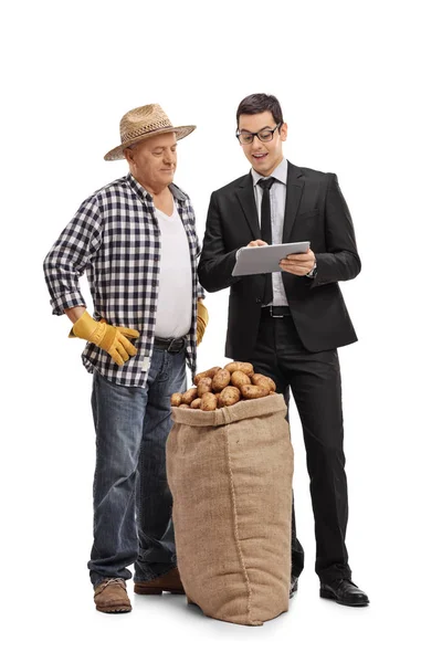 Businessman showing something on a tablet to a farmer — Stock Photo, Image