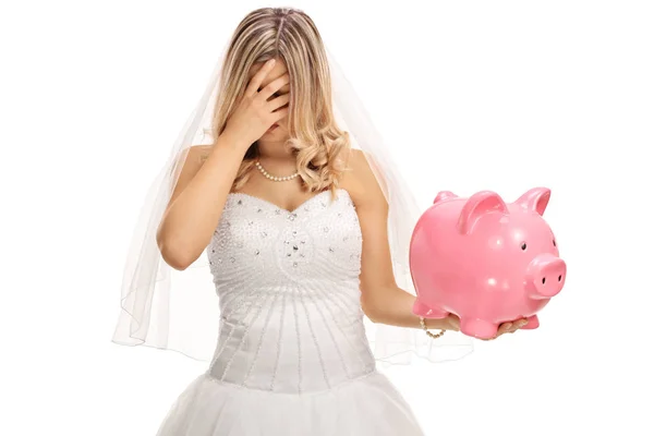 Disappointed bride holding a piggybank — Stock Photo, Image