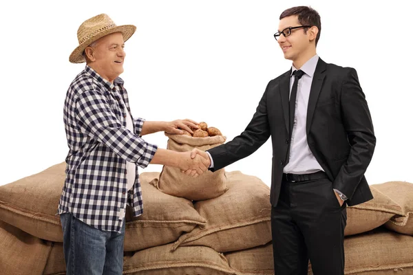 Фермер и бизнесмен пожимают друг другу руки — стоковое фото