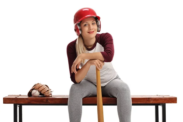 Γυναίκα με ένα κράνος και ένα ρόπαλο του μπέιζμπολ που κάθεται σε ένα παγκάκι — Φωτογραφία Αρχείου