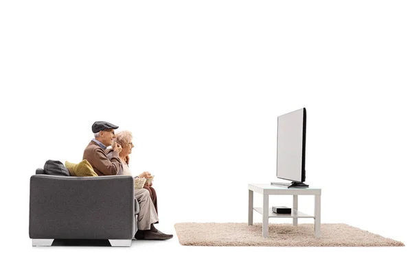 Seniors eating popcorn and watching television — Stock Photo, Image