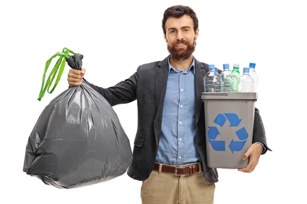 Chlap drží pytel smetí a recyklace bin — Stock fotografie