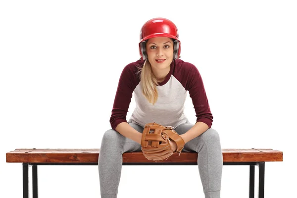 Female baseball player sitting on a bench — Stock Photo, Image