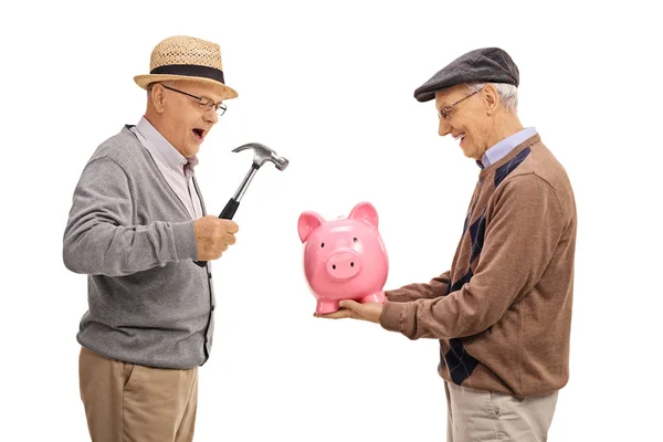 Men preparing to break a piggybank with a hammer — Stock Photo, Image