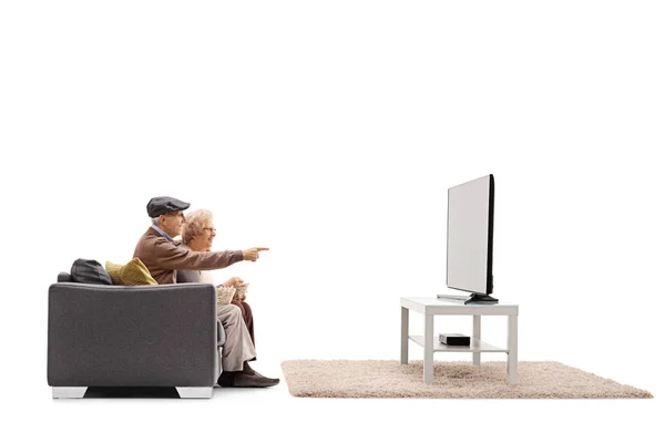 Homme et femme assis sur un canapé et regardant la télévision — Photo