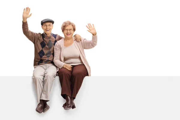 Pareja de ancianos sentados en un panel y saludando — Foto de Stock