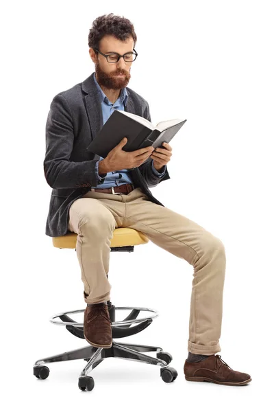 Hombre sentado en una silla y leyendo un libro — Foto de Stock