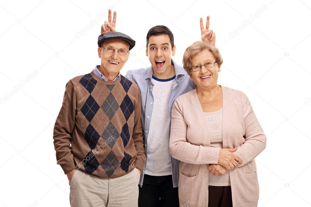 man pranking a mature man and woman with bunny ears