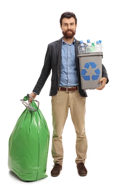 Homem com uma lixeira cheia de garrafas de plástico e um saco de lixo — Fotografia de Stock