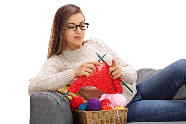 Fröhliche Frau, die auf einem Sofa liegt und strickt — Stockfoto