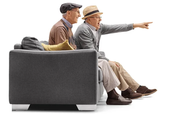 Hombres maduros sentados en un sofá con uno de ellos señalando — Foto de Stock