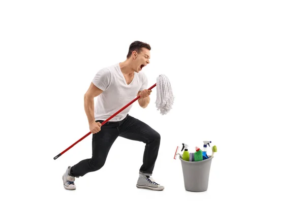Young man singing on a mop — Stock Photo, Image
