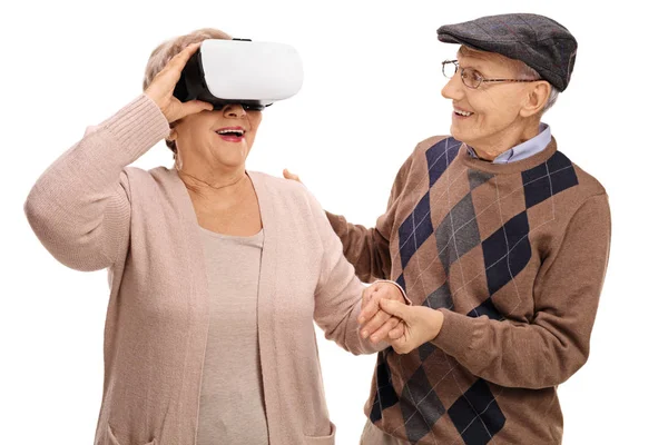Mujer usando un casco VR con un hombre sosteniendo su mano — Foto de Stock