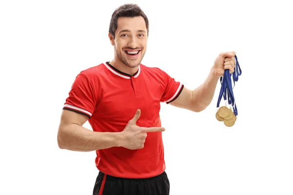 Jogador de futebol segurando medalhas de ouro e apontando — Fotografia de Stock