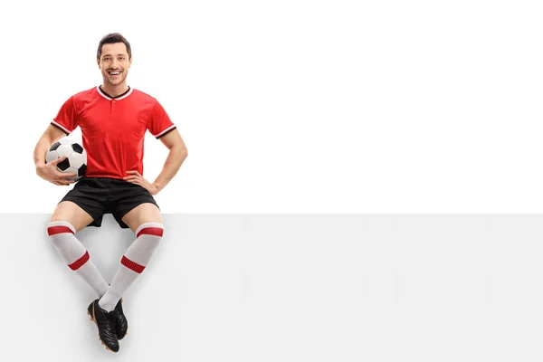 Buon giocatore di calcio seduto su un pannello — Foto Stock