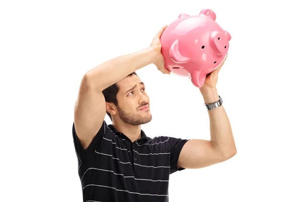 Bezorgd kerel schudden een spaarpot — Stockfoto