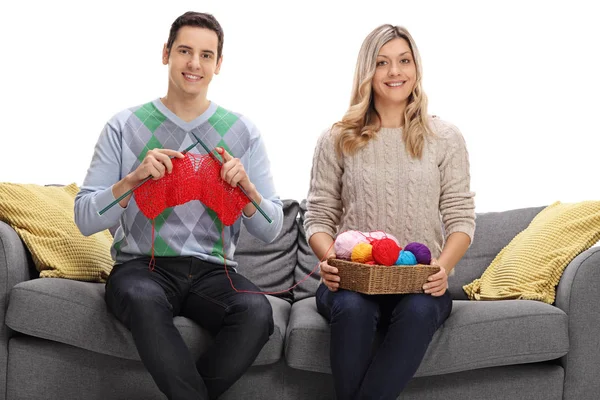 Couple sitting on a sofa and knitting together — Stock Photo, Image