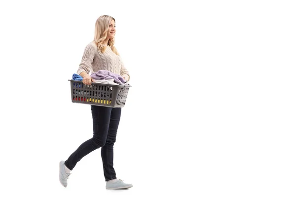 Mujer llevando una cesta de ropa llena de ropa — Foto de Stock