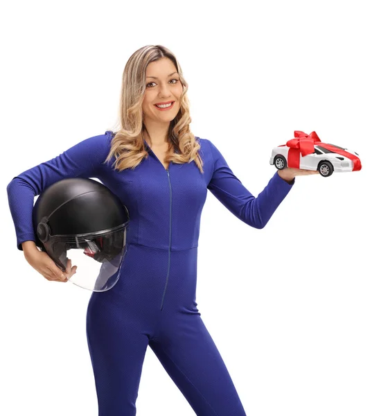 Female car racer holding helmet and model car — Stock Photo, Image