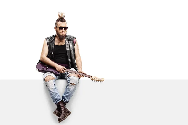 Punker mit E-Gitarre sitzt auf einer Platte — Stockfoto