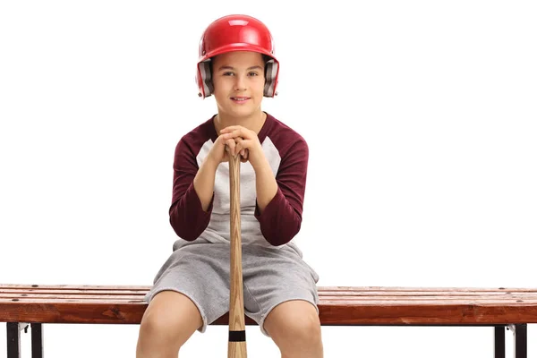 Rapaz com um capacete e um taco de basebol sentado num banco — Fotografia de Stock