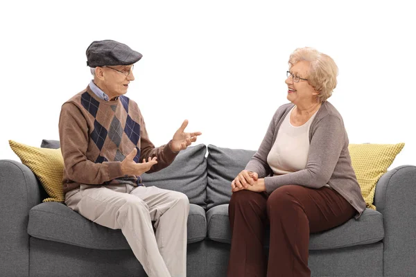 Мужчина и женщина старшего возраста сидят на диване и разговаривают — стоковое фото