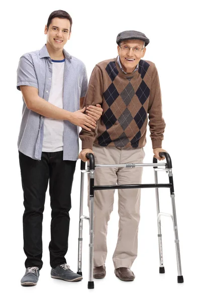 Young man helping a mature man with a walker — Stock Photo, Image