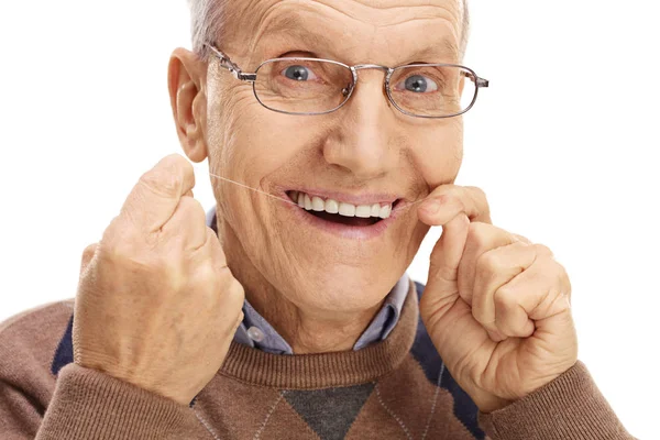 Зрелый человек чистит зубы нитью — стоковое фото