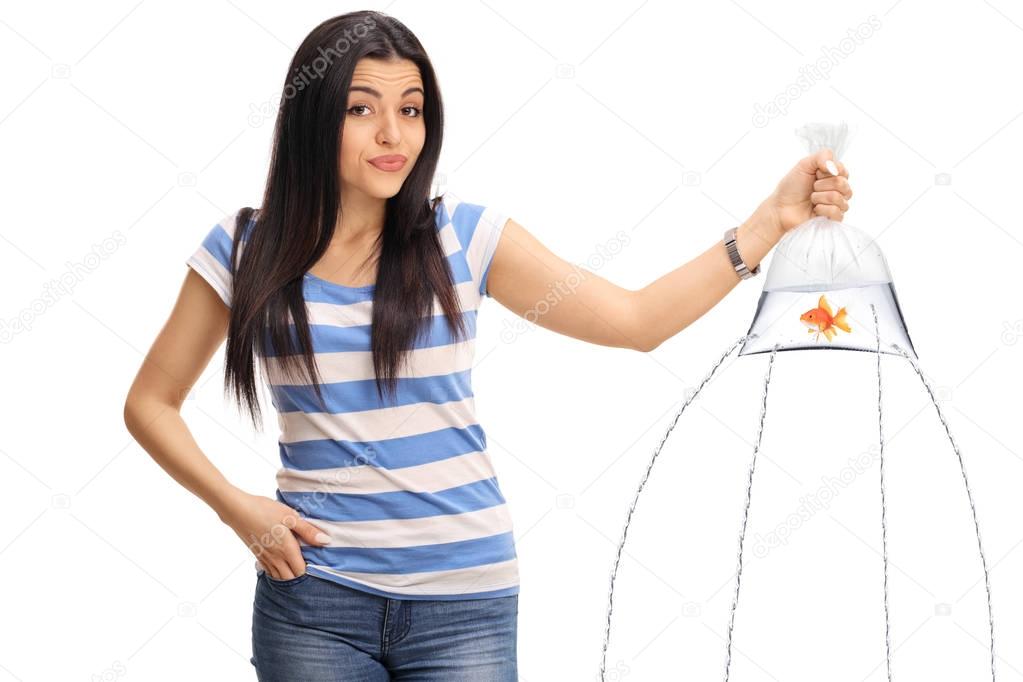 Confused girl holding a goldfish in bag with water leaking