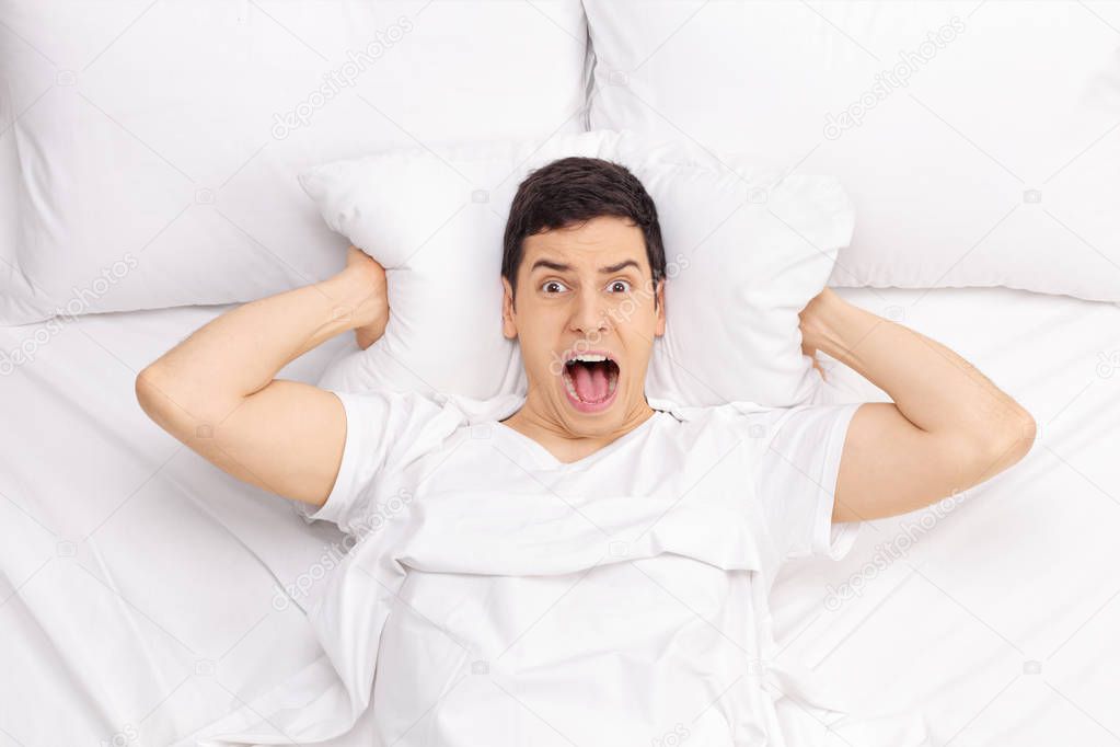 Man in bed screaming