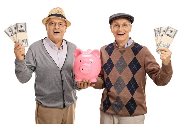 Personas mayores felices con paquetes de dinero y una hucha —  Fotos de Stock