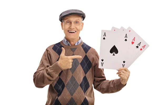 Cheerful senior holding four aces and pointing — Stock Photo, Image