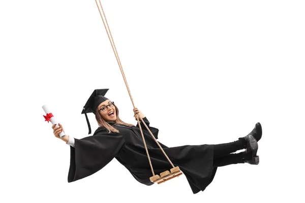 Graduado estudante titular de diploma e balançando no balanço — Fotografia de Stock