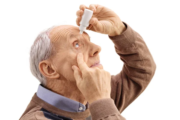 Hombre mayor aplicando gotas para los ojos —  Fotos de Stock
