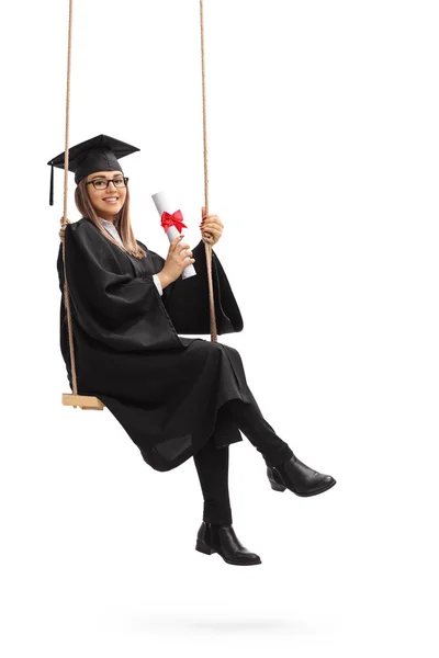 Аспирант с дипломом, сидящий на качелях — стоковое фото