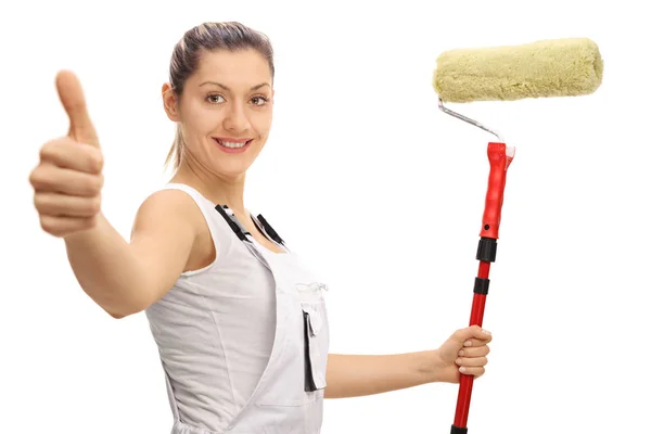 Kvinnliga målare holding paint roller och ger tummen upp — Stockfoto