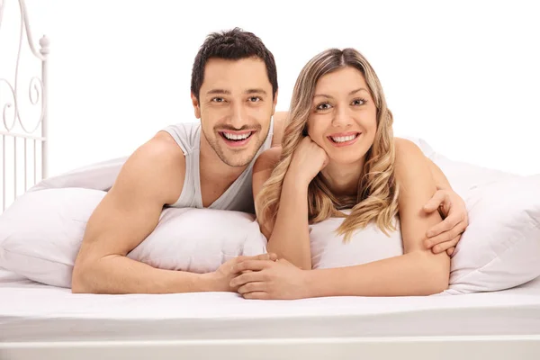 Par i sängen och tittar på kameran — Stockfoto
