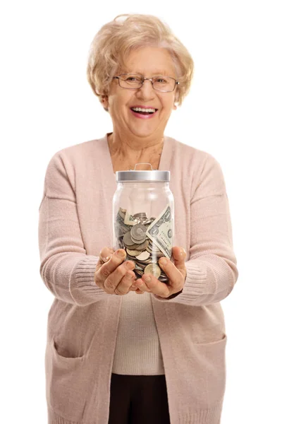 Зрелая женщина держит банку, наполненную деньгами — стоковое фото