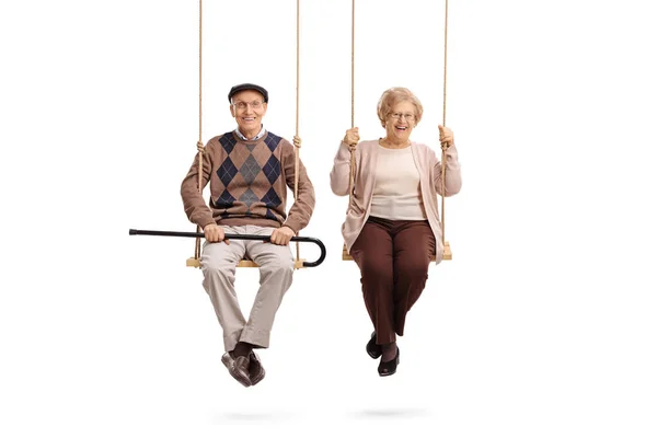 Elderly man and an elderly woman sitting on swings — Stock Photo, Image