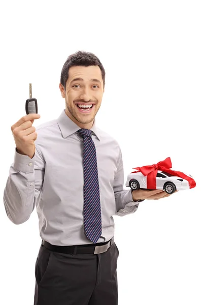 Wesoły biznesmen trzymając klucz i modelu samochodu — Zdjęcie stockowe