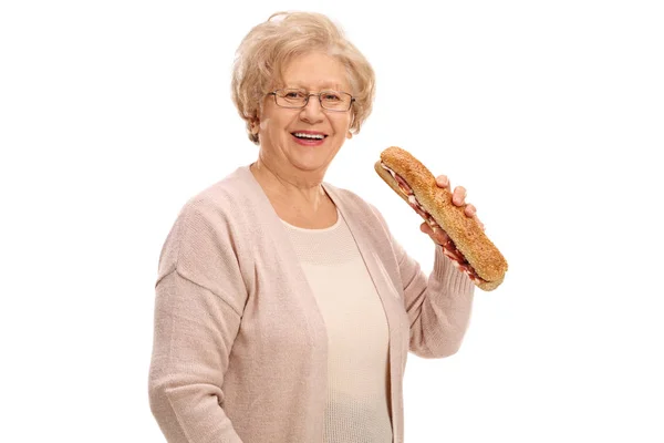 Veselý starší žena s sendvič — Stock fotografie