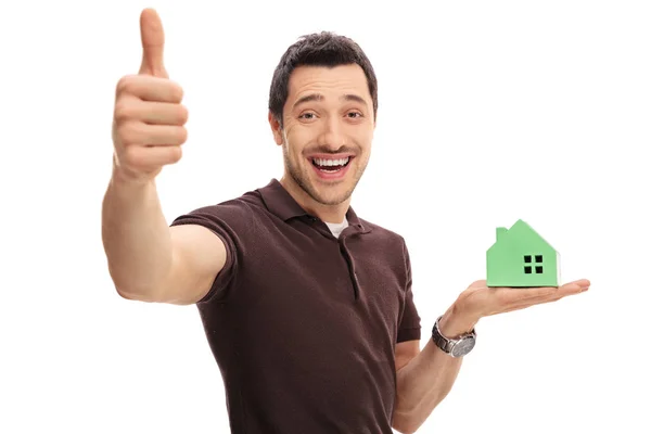 Man making thumb up gesture and holding model house — Stock Photo, Image