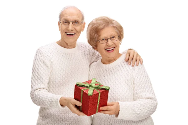 Joyful seniors with a present — Stock Photo, Image